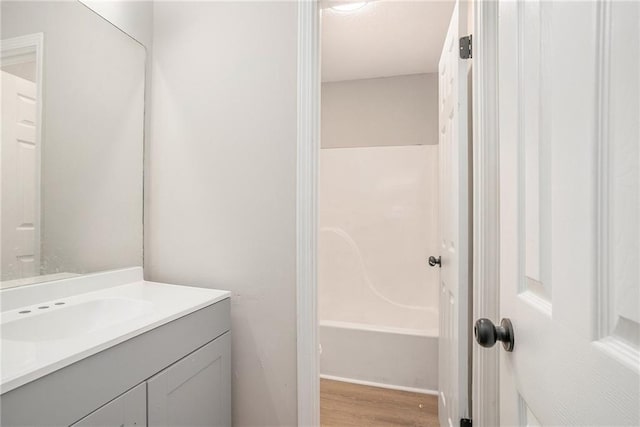 full bathroom featuring wood finished floors and vanity