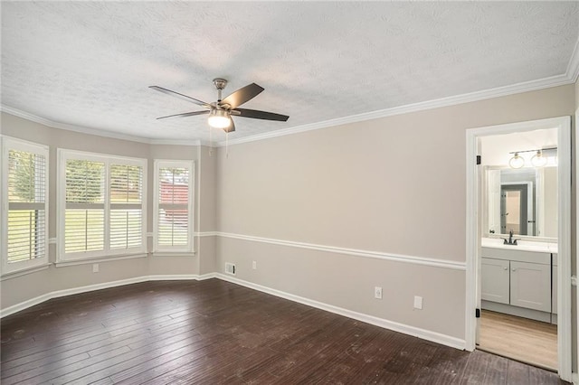 unfurnished room with crown molding, dark wood finished floors, a sink, a textured ceiling, and baseboards