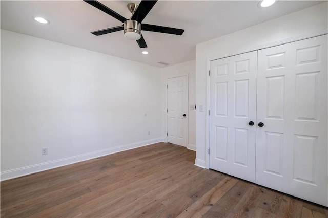 unfurnished bedroom with ceiling fan, a closet, and hardwood / wood-style floors