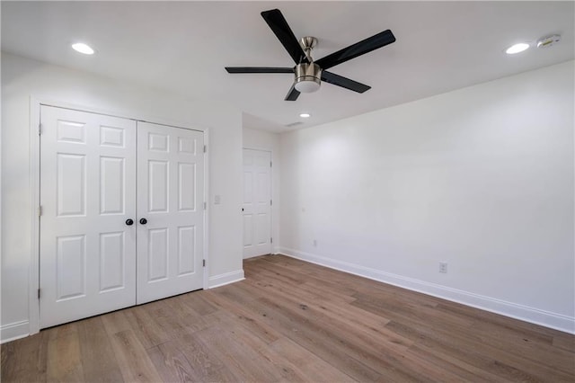 unfurnished bedroom with ceiling fan, light hardwood / wood-style floors, and a closet