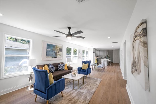 living room featuring ceiling fan and light hardwood / wood-style floors