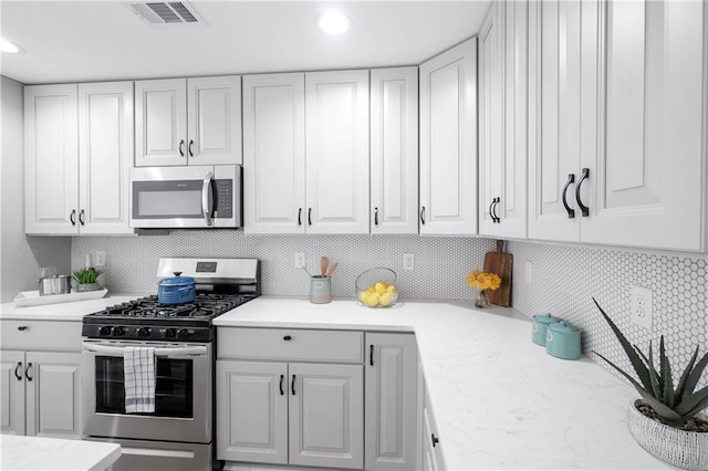 kitchen featuring backsplash, white cabinetry, and stainless steel appliances