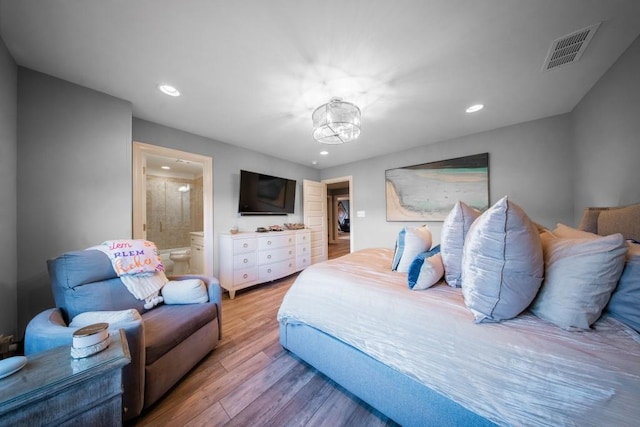 bedroom featuring ensuite bathroom and light wood-type flooring