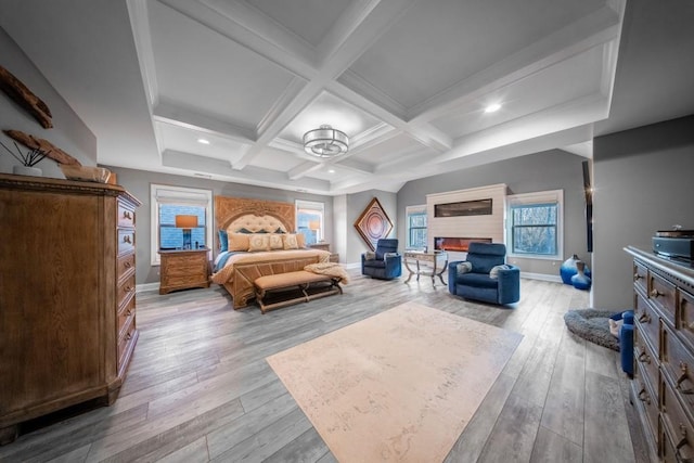 bedroom featuring coffered ceiling, beam ceiling, and light wood-type flooring