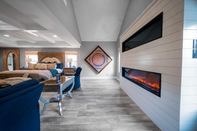 bedroom featuring coffered ceiling, beamed ceiling, a fireplace, and light wood-type flooring