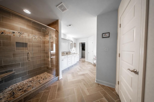 bathroom with vanity, a shower with shower door, and parquet flooring