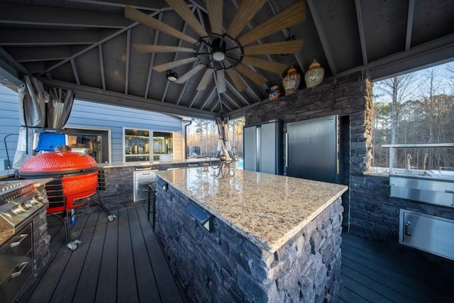 deck featuring ceiling fan, an outdoor kitchen, and an outdoor bar