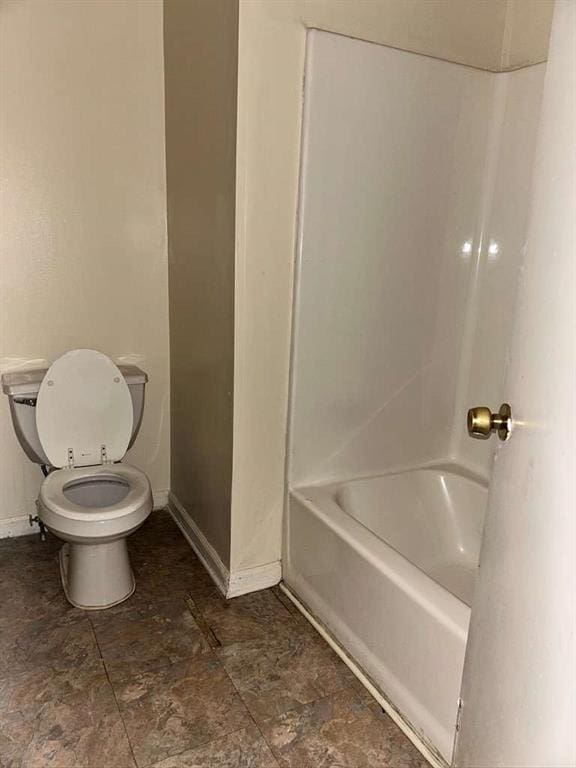 full bath featuring toilet and baseboards