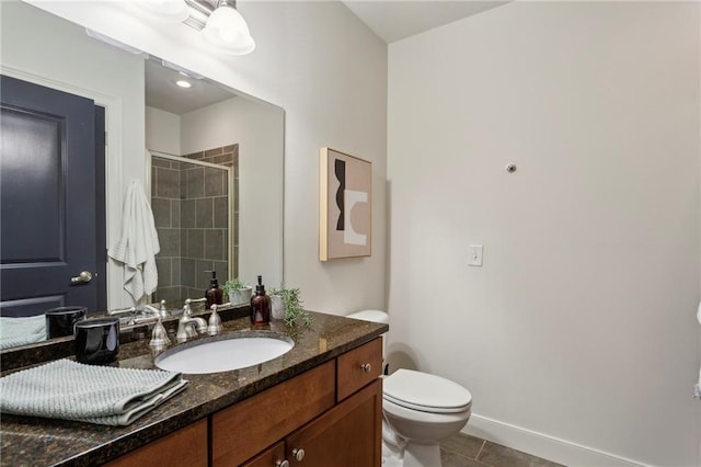 bathroom with a stall shower, tile patterned floors, vanity, toilet, and baseboards