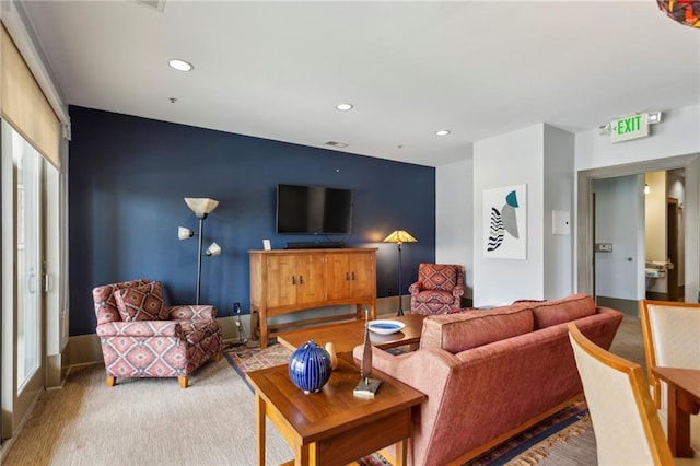 living room featuring recessed lighting and an accent wall