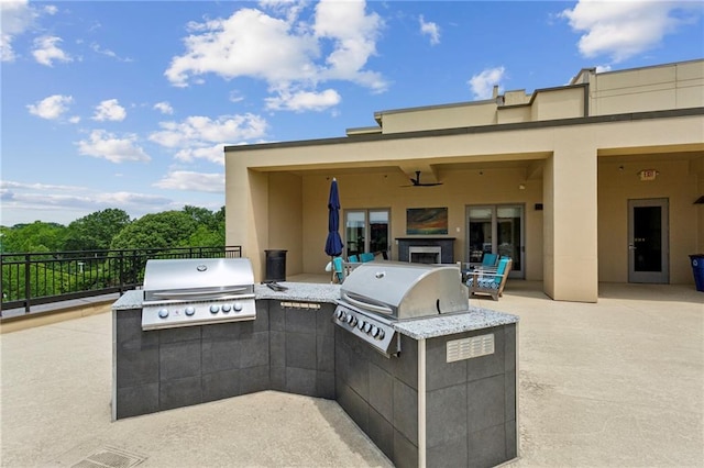 view of patio with an outdoor kitchen, a grill, and fence
