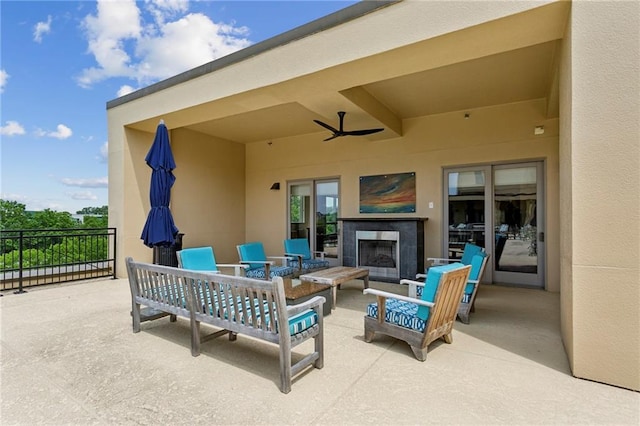 view of patio / terrace featuring ceiling fan and an outdoor living space with a fireplace