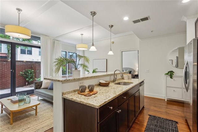 kitchen featuring a sink, stainless steel appliances, dark brown cabinetry, dark wood-style floors, and pendant lighting