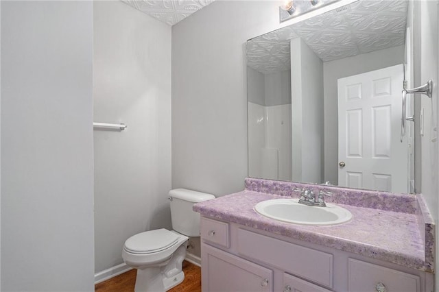 bathroom with hardwood / wood-style floors, vanity, and toilet