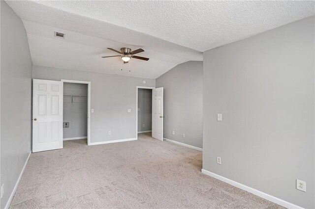 unfurnished bedroom featuring lofted ceiling, ceiling fan, and light colored carpet