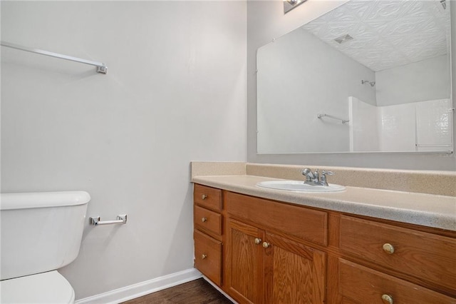 bathroom with vanity, a shower, toilet, and hardwood / wood-style flooring