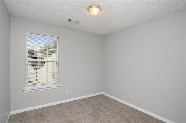 unfurnished room with a textured ceiling and carpet flooring