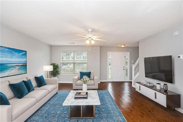 living room with ceiling fan and dark wood-type flooring