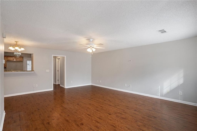 unfurnished room featuring ceiling fan with notable chandelier, a textured ceiling, and dark hardwood / wood-style flooring