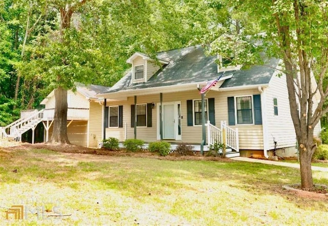 cape cod-style house with a front lawn and covered porch