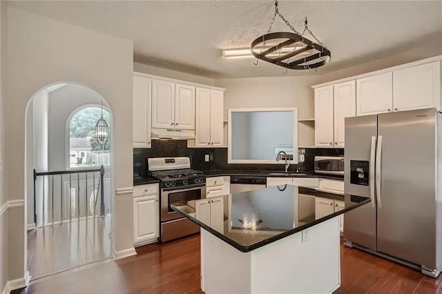 kitchen featuring white cabinets, a center island, sink, and appliances with stainless steel finishes