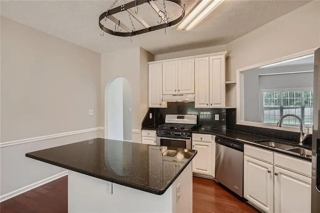 kitchen featuring white cabinets, appliances with stainless steel finishes, a center island, and sink