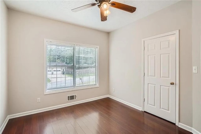 spare room featuring ceiling fan and dark wood-type flooring