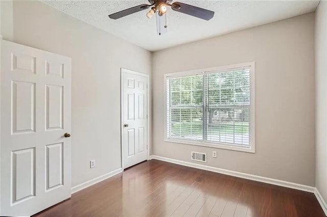 unfurnished room featuring ceiling fan and dark wood-type flooring
