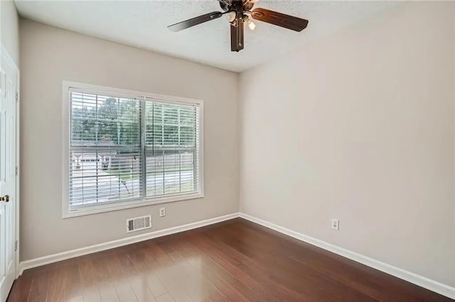 empty room with ceiling fan and dark hardwood / wood-style floors