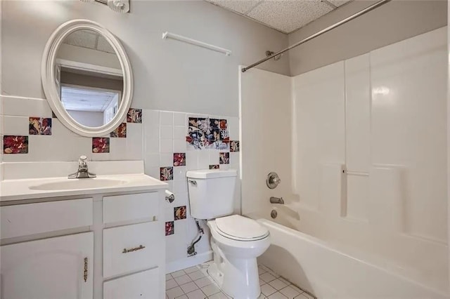full bathroom featuring tile patterned floors, shower / bath combination, toilet, vanity, and tile walls