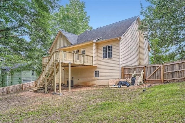 rear view of house with a yard, central AC unit, and a deck