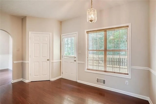 foyer entrance featuring dark hardwood / wood-style flooring and an inviting chandelier