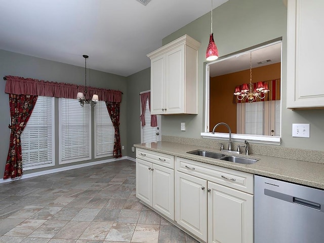 kitchen with a chandelier, stainless steel dishwasher, light countertops, and a sink