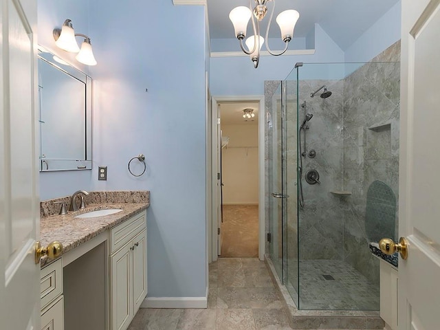 full bathroom featuring a stall shower, a walk in closet, a chandelier, and vanity