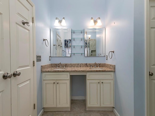bathroom featuring double vanity, a sink, and baseboards