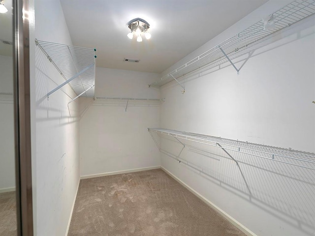 walk in closet featuring visible vents and carpet