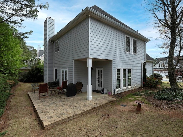 back of house featuring a chimney and a patio