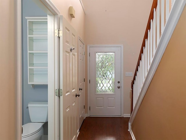entryway featuring dark wood-type flooring, baseboards, and stairs