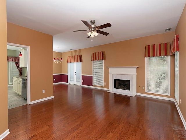 unfurnished living room featuring a fireplace, ceiling fan, wood finished floors, and baseboards