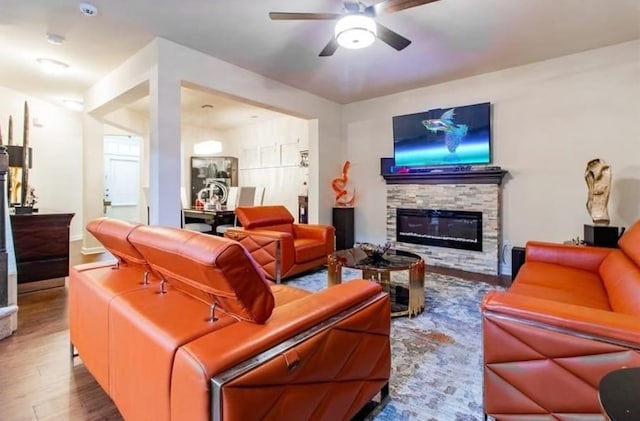 living room with wood-type flooring, a fireplace, and ceiling fan