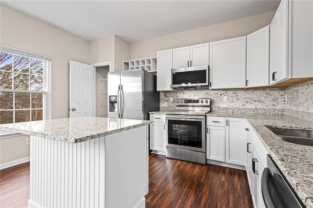 kitchen featuring white cabinets, light stone countertops, dark wood-type flooring, and appliances with stainless steel finishes