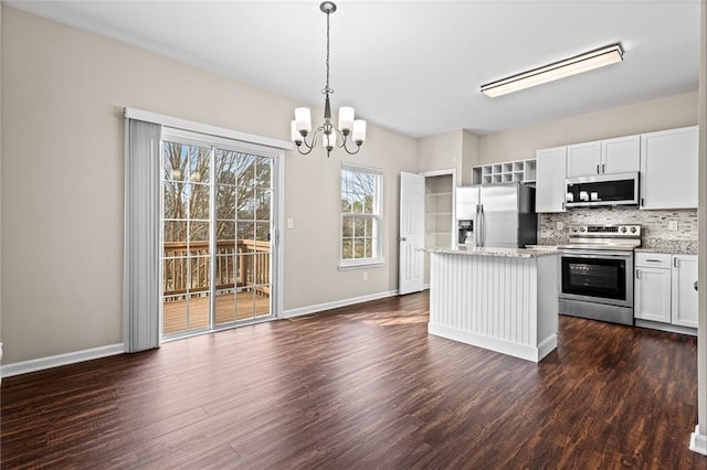 kitchen with white cabinets, appliances with stainless steel finishes, a kitchen island, and pendant lighting