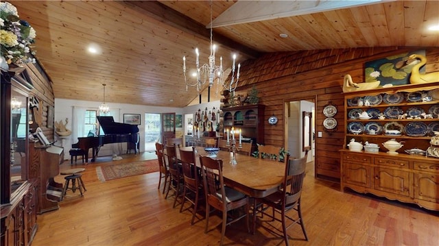 dining area featuring light wood-style floors, wood ceiling, and a notable chandelier