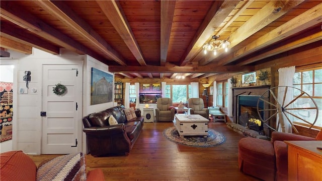 living area featuring wooden ceiling, wood-type flooring, a fireplace with raised hearth, and beam ceiling