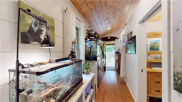 hall featuring wooden ceiling, vaulted ceiling, and light wood finished floors