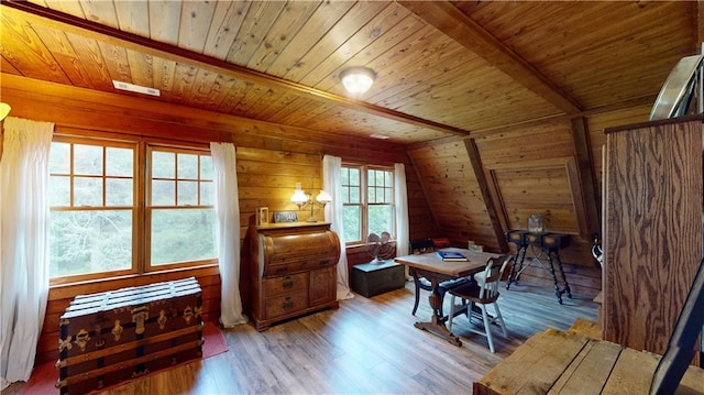 living area with visible vents, wood ceiling, wood walls, wood finished floors, and beamed ceiling