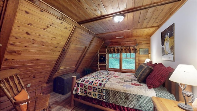 bedroom featuring vaulted ceiling, wood finished floors, wood ceiling, and wooden walls