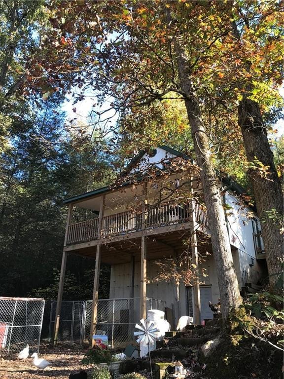 rear view of house featuring fence and a balcony