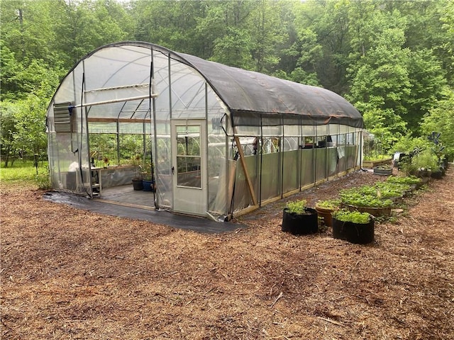 view of greenhouse featuring a view of trees