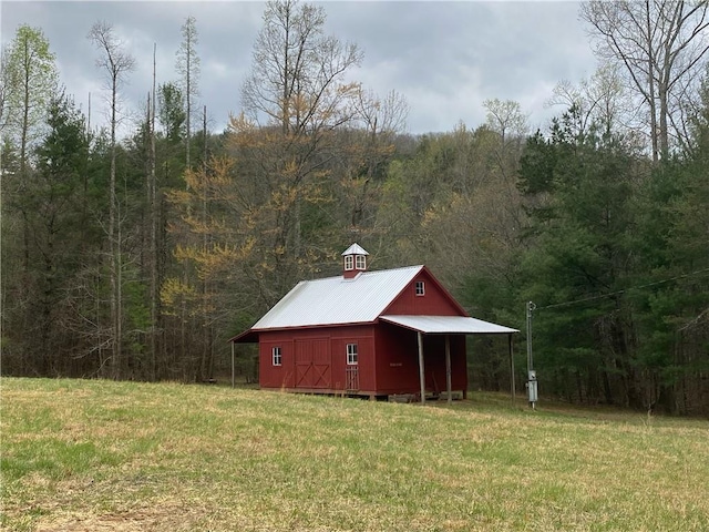 view of outdoor structure featuring a forest view and an outdoor structure